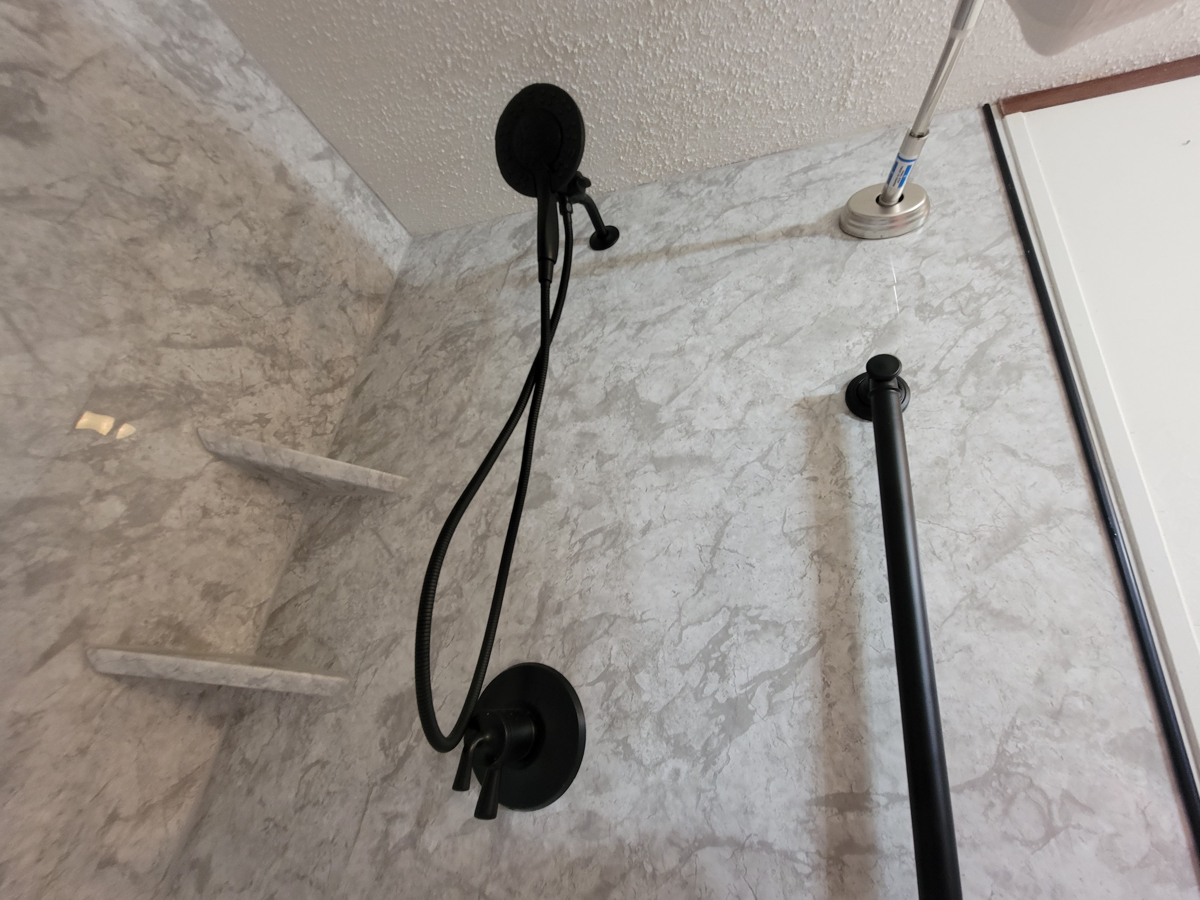 New gray marble walls and black shower head